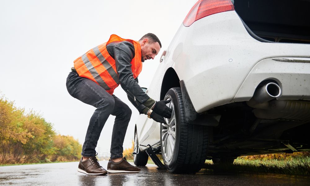 Roadside technician assisting with a flat tire change