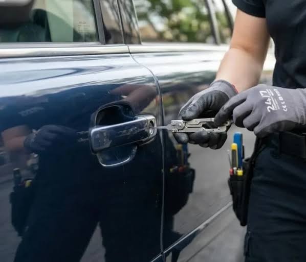 Technician assisting with a vehicle door lockout